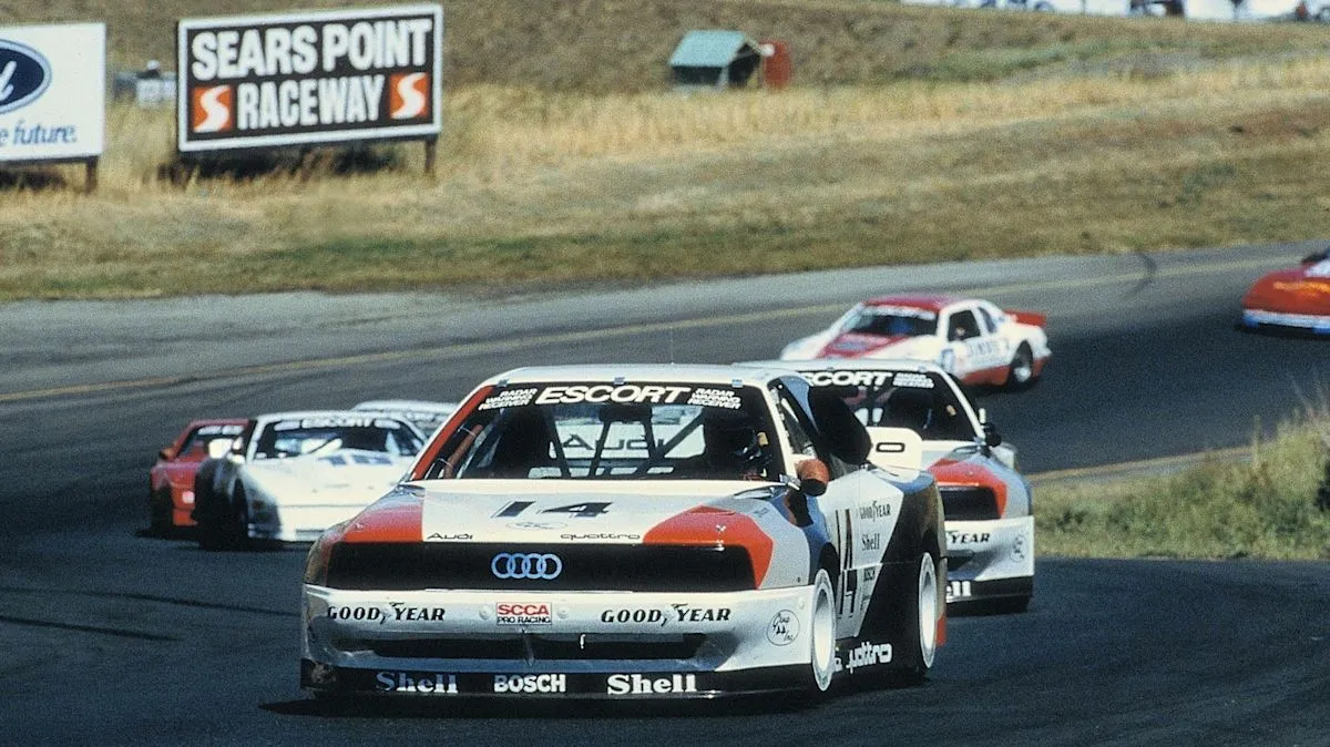 Mobil balap Audi klasik dengan livery balap legendaris di lintasan sirkuit
