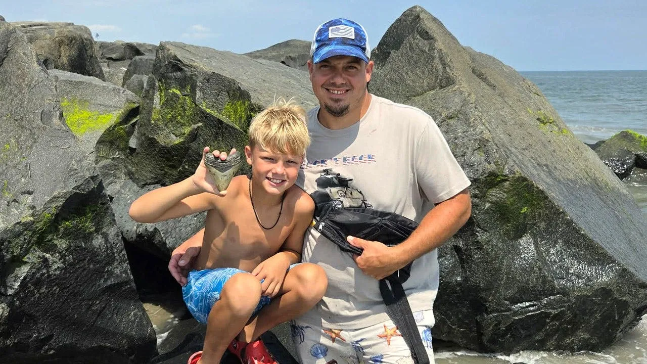 Bo Bowers dan ayahnya menunjukkan fosil gigi megalodon yang ditemukan di pantai Sea Isle City
