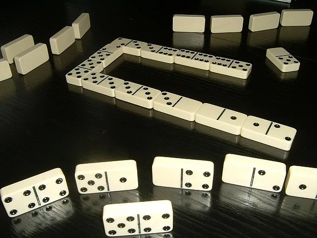 Set domino tradisional yang menampilkan kombinasi angka dan pola titik yang ikonik